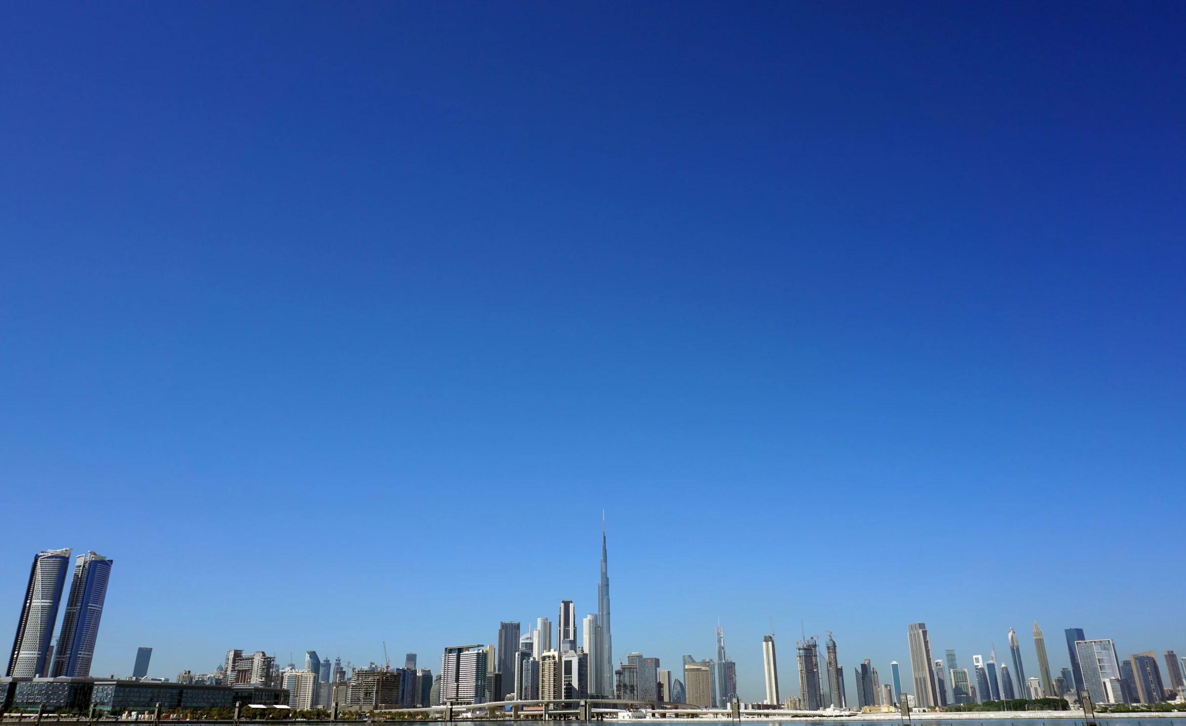 Dubai skyline and Burj Khalifa beneath a wide clear blue sky
